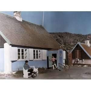  Two Greenlanders Stand Outside their Vividly Painted Home 